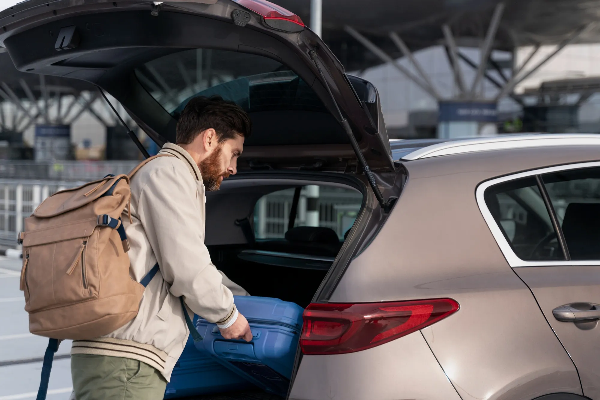 Man loading suitcase into taxi at Manchester Airport — Manchester 24/7 Transfers